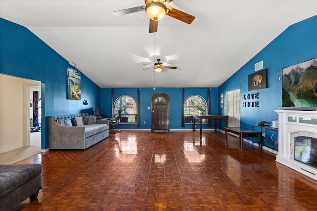 living area featuring visible vents, baseboards, a ceiling fan, a premium fireplace, and high vaulted ceiling