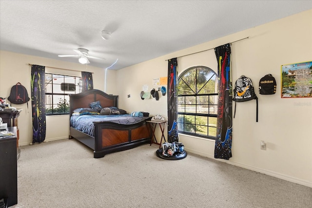 bedroom with carpet, baseboards, ceiling fan, and a textured ceiling