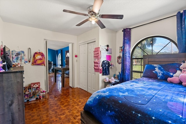 bedroom with a textured ceiling, a closet, and a ceiling fan