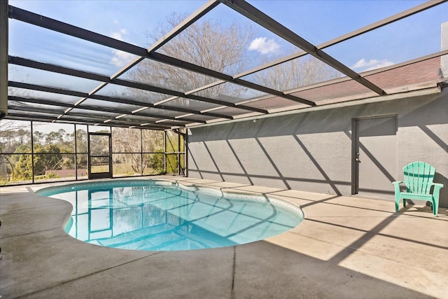 pool with glass enclosure and a patio area