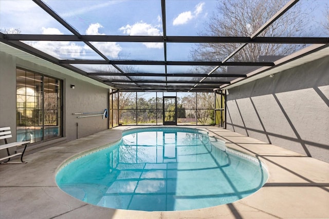 outdoor pool with glass enclosure and a patio area