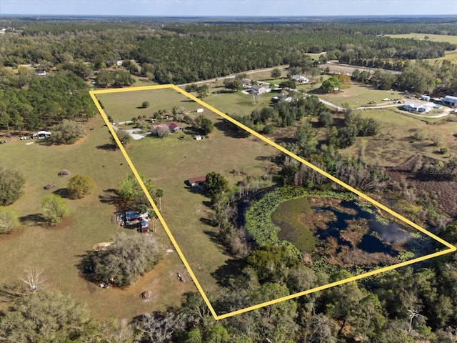 bird's eye view with a wooded view