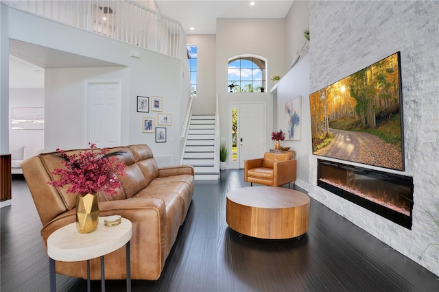 living room with dark hardwood / wood-style flooring and a towering ceiling