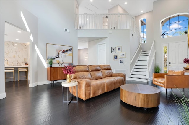 living room with dark hardwood / wood-style flooring and a high ceiling