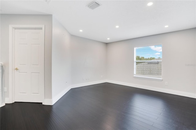 empty room with dark hardwood / wood-style flooring