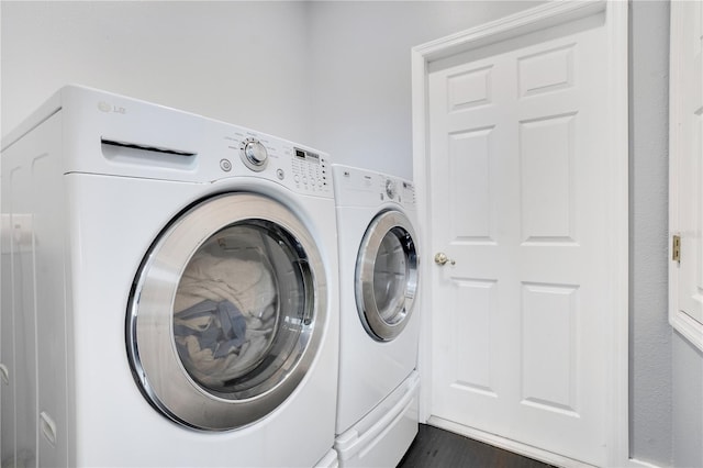 laundry room with dark hardwood / wood-style floors and washer and dryer