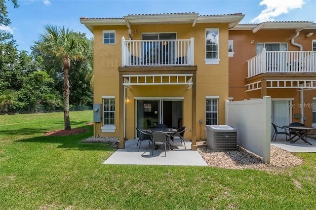 back of house featuring a lawn, cooling unit, a balcony, and a patio