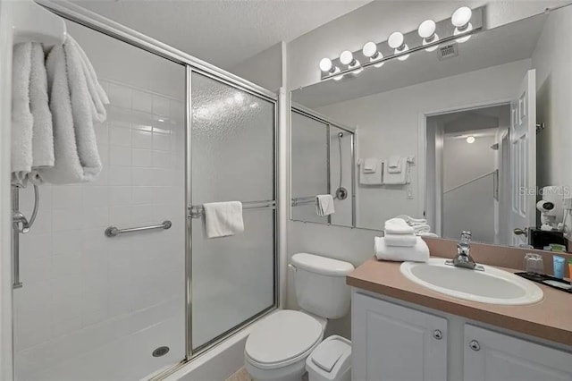 bathroom with a shower with door, a textured ceiling, toilet, and vanity