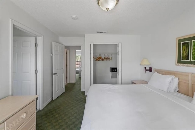 bedroom featuring a closet and dark colored carpet