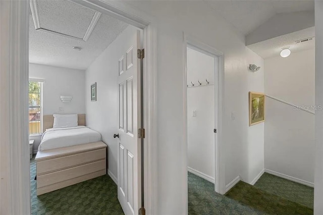 bedroom with a textured ceiling, dark colored carpet, and lofted ceiling