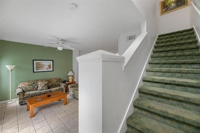 staircase featuring ceiling fan and tile patterned floors