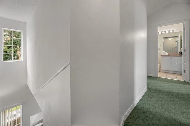 corridor featuring lofted ceiling and light carpet