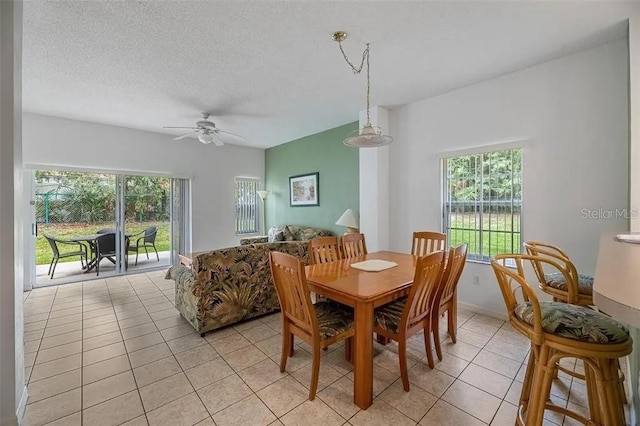 tiled dining room with ceiling fan and a textured ceiling