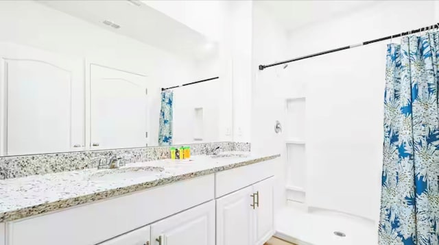 bathroom with walk in shower and vanity