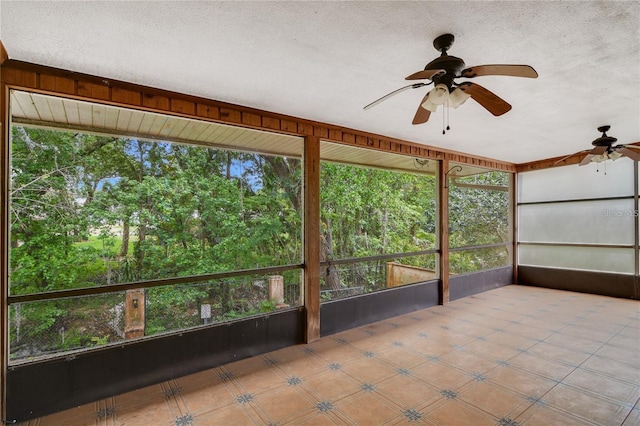 unfurnished sunroom with ceiling fan