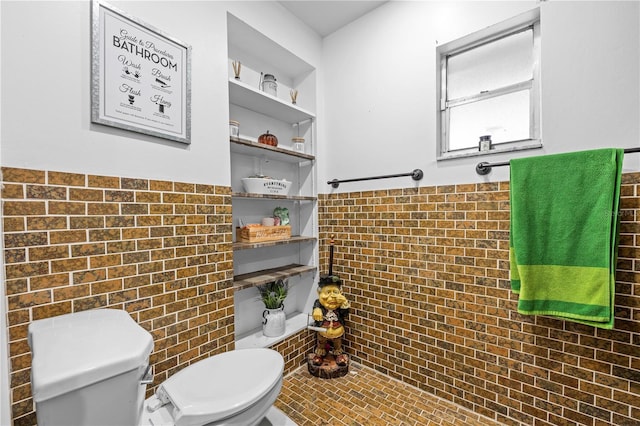 bathroom featuring built in shelves, tile walls, toilet, and tile patterned flooring