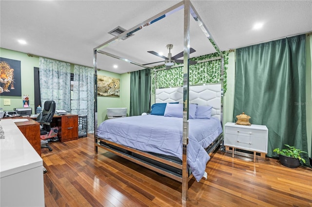 bedroom with ceiling fan, hardwood / wood-style floors, a wall of windows, and a textured ceiling