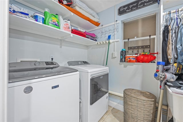 laundry room featuring light tile patterned flooring and washing machine and clothes dryer