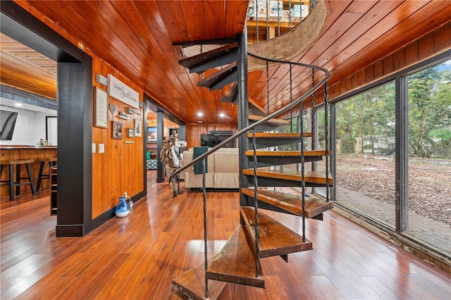 stairs with wood ceiling, wooden walls, and wood-type flooring