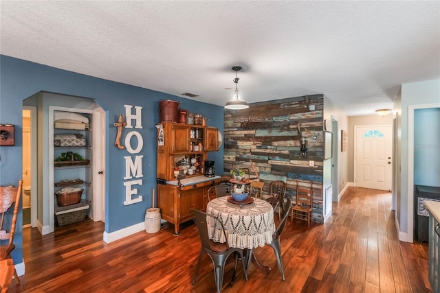 dining area featuring a textured ceiling and dark hardwood / wood-style floors