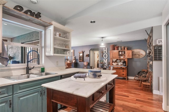 kitchen with lofted ceiling, light hardwood / wood-style floors, and sink