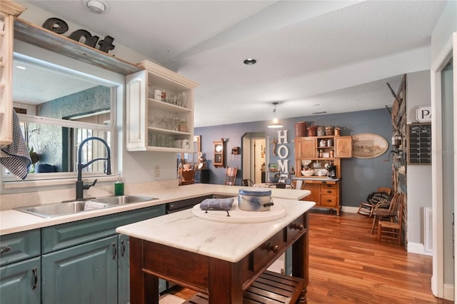 kitchen with light hardwood / wood-style floors, sink, lofted ceiling, and kitchen peninsula