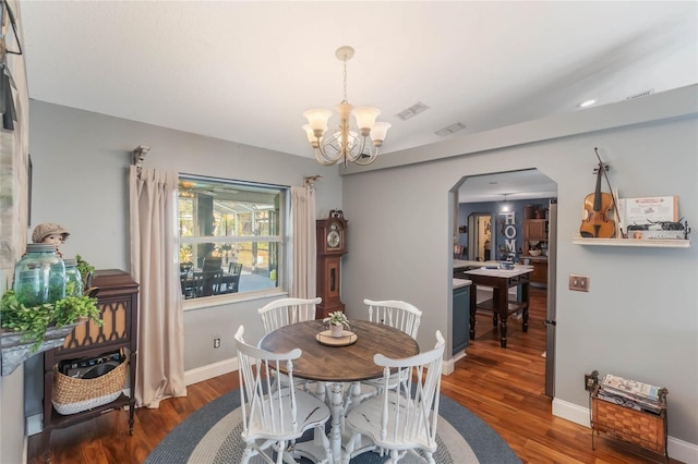 dining space featuring dark hardwood / wood-style floors and a notable chandelier