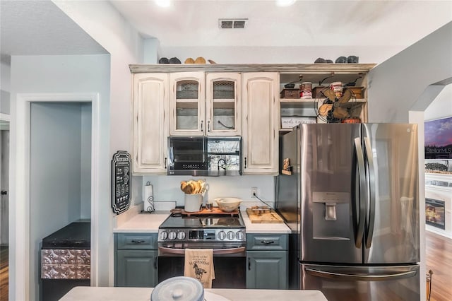 kitchen with stainless steel appliances, gray cabinetry, and hardwood / wood-style flooring