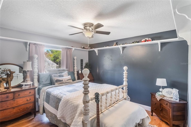 bedroom with a textured ceiling, ceiling fan, and hardwood / wood-style flooring