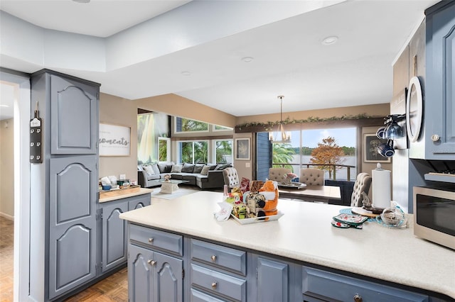 kitchen with decorative light fixtures, light parquet floors, and blue cabinetry