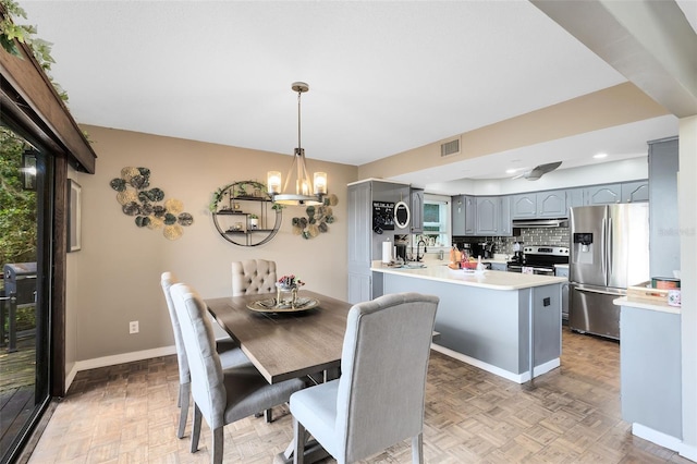 dining room with light parquet floors and a chandelier