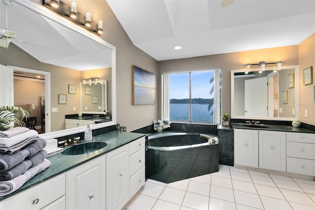 bathroom featuring tiled tub, tile patterned floors, vanity, vaulted ceiling, and ceiling fan