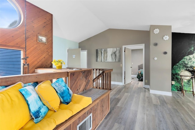 hall with lofted ceiling and hardwood / wood-style floors