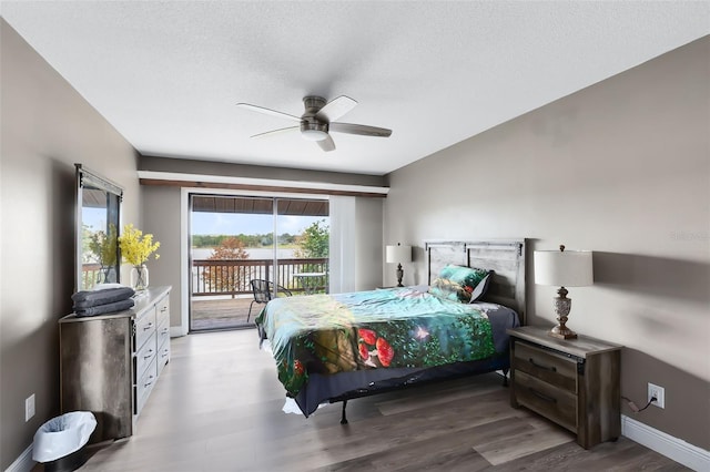 bedroom featuring ceiling fan, a textured ceiling, hardwood / wood-style flooring, and access to outside