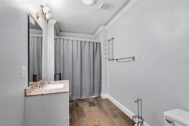 bathroom with vanity, toilet, walk in shower, ornamental molding, and hardwood / wood-style flooring