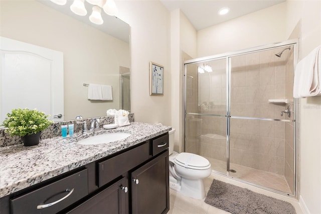 bathroom featuring a shower with door, toilet, vanity, and tile patterned flooring