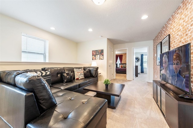 living room featuring light colored carpet, brick wall, and a textured ceiling