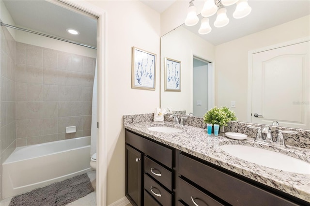 full bathroom with tiled shower / bath, tile patterned floors, vanity, toilet, and a chandelier