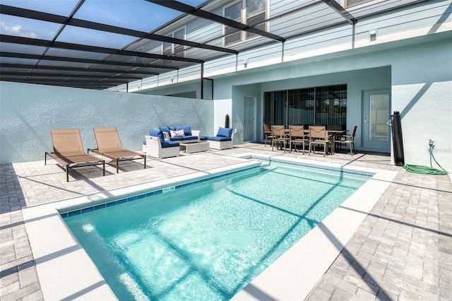 view of swimming pool featuring glass enclosure, outdoor lounge area, and a patio