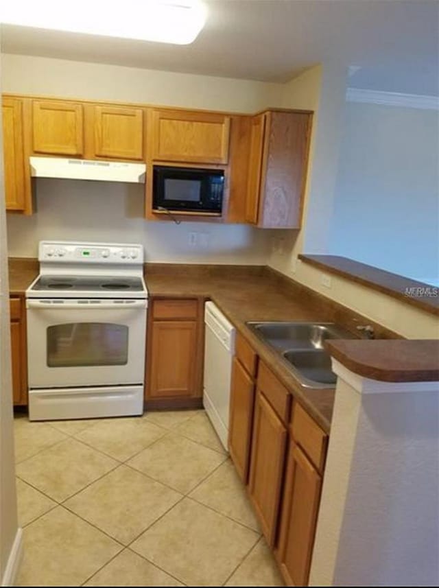 kitchen with sink, white appliances, light tile patterned floors, and crown molding