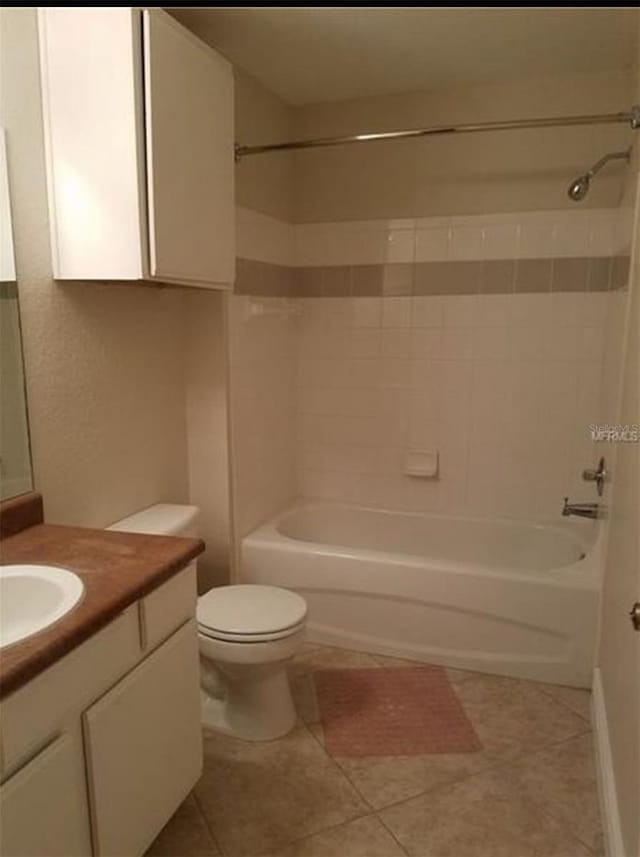 full bathroom featuring toilet, vanity, tile patterned flooring, and tiled shower / bath combo