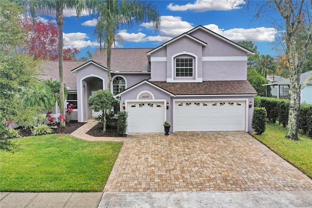 front facade with a garage and a front lawn