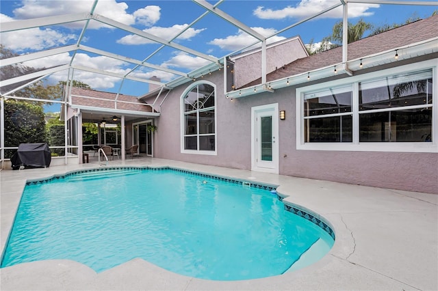 view of swimming pool featuring a patio area and a lanai