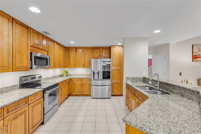 kitchen featuring appliances with stainless steel finishes, light tile patterned floors, sink, kitchen peninsula, and light stone counters