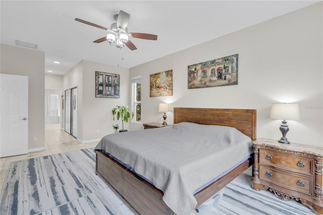 bedroom with a closet, ceiling fan, ensuite bathroom, and light tile patterned flooring