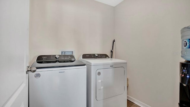 laundry area featuring washing machine and dryer and dark hardwood / wood-style floors