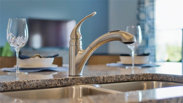 interior details with sink and dark stone countertops