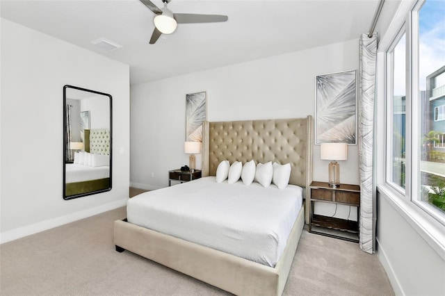 carpeted bedroom featuring multiple windows and ceiling fan