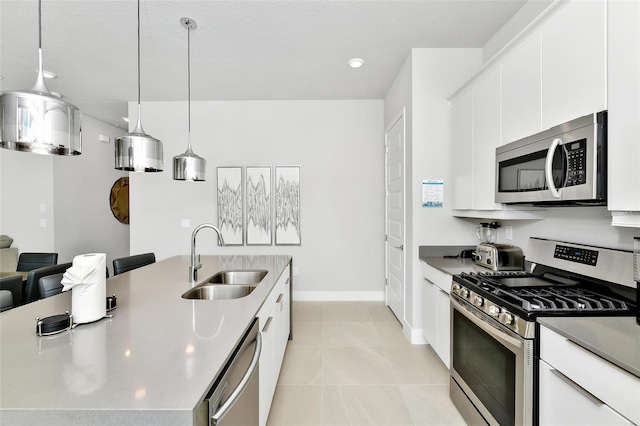 kitchen with sink, decorative light fixtures, stainless steel appliances, and white cabinets