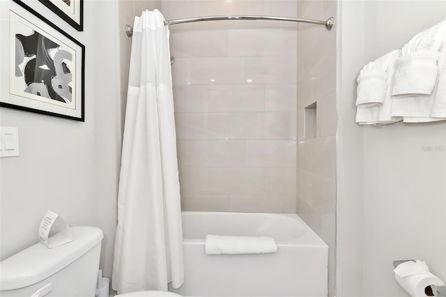 bathroom featuring shower / tub combo and toilet